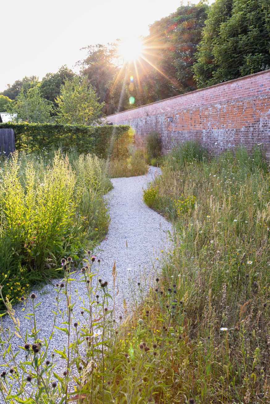 Colm Joseph suffolk walled garden design curved limestone gravel path through wildflower meadow old brick wall beech hedge